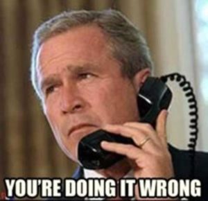 Photo of president Bush holding the phone upside down, saying 