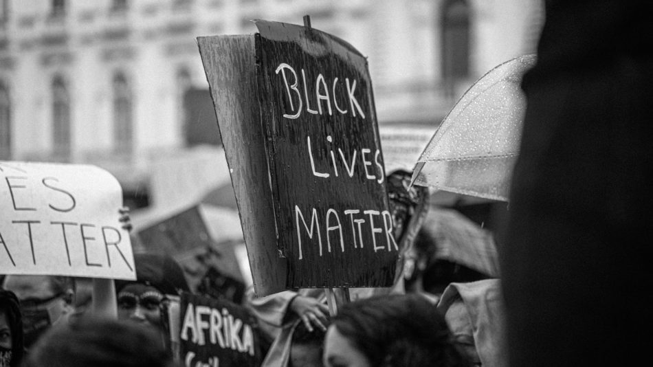 unrecognizable activists with black lives matter title on placard