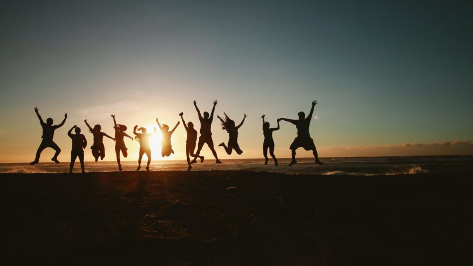 silhouette photography of group of people jumping during golden time